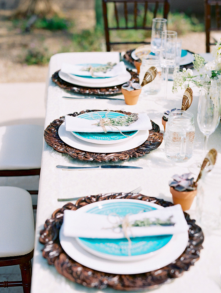 Party table set with carved wood plates with a bright pop of turquoise