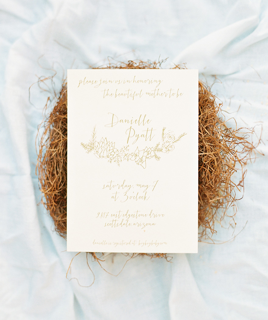 Elegant invitation tucked into a rustic nest
