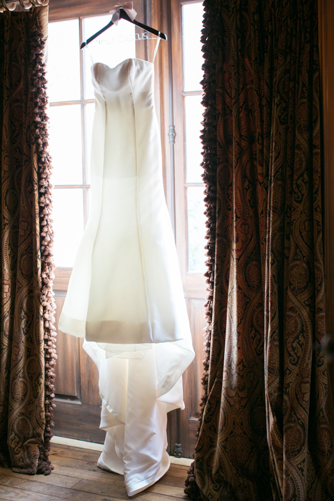 Strapless fit-and-fare wedding gown hangs in the window