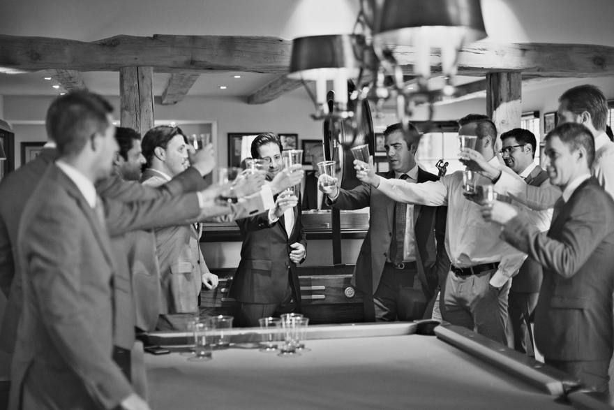 A room full of groomsmen toasting the groom on his wedding day