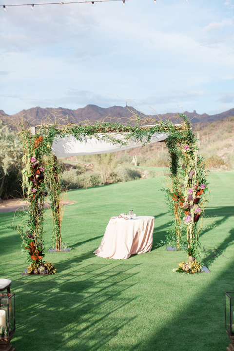 Draped chuppa decorated with flowers and vegetables. Outdoor wedding ceremony