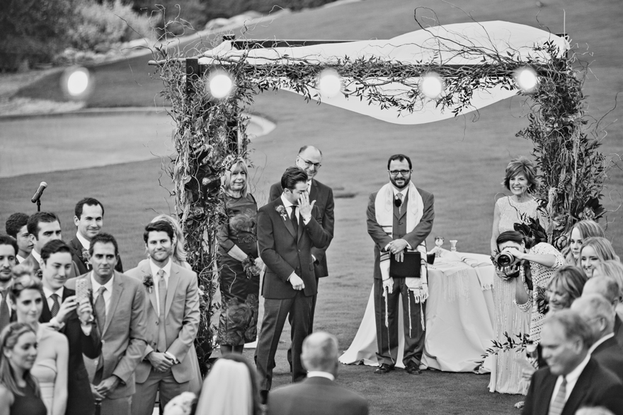 Groom cries as he sees his bride walking down the aisle. Outdoor wedding