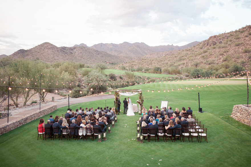 Wide shot of an outdoor wedding ceremony with the Arizona mountains and desert in the background