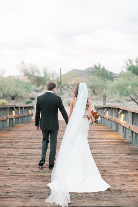 Bride and groom cross a wooden bride. 