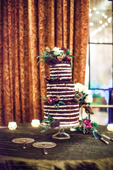 Three tier naked cake. Chocolate wedding cake decorated with flowers and figs.