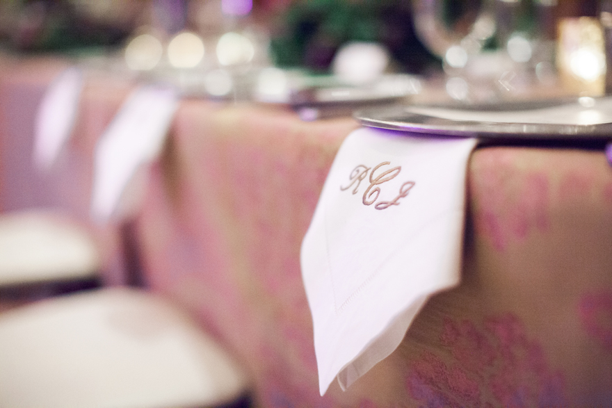 Brocade tablecloth and monogrammed napkins at an elegant wedding reception