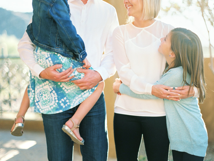 Bride and groom hold children showing love in a family photo shoot!