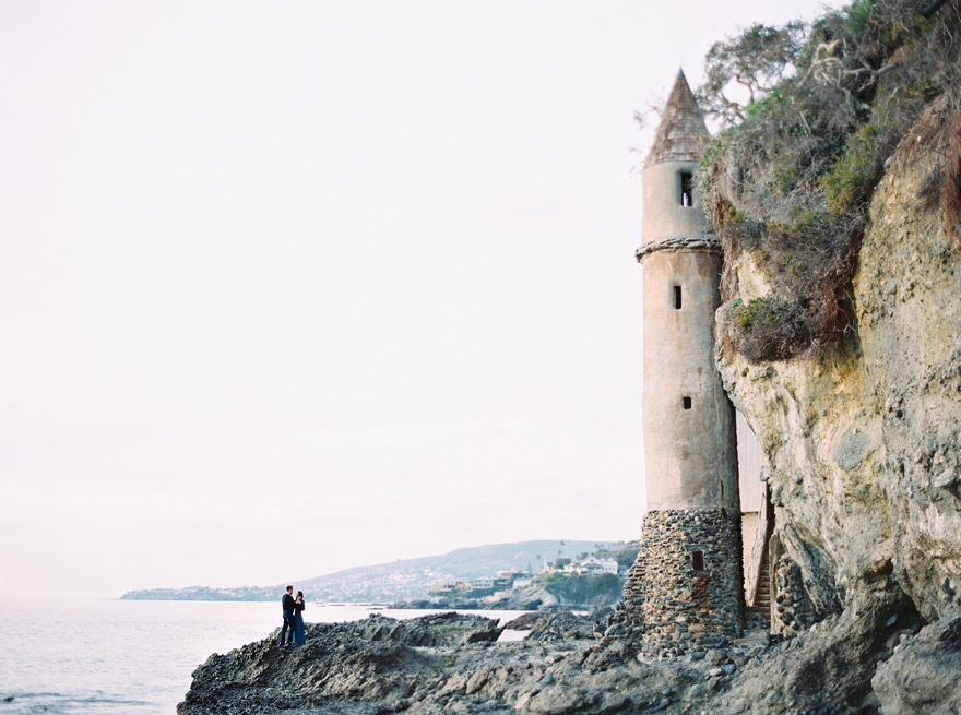 embracing on rocks beside La Tour at Victoria Beach