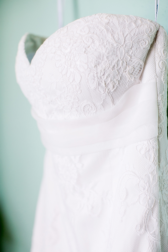 White strapless a-line wedding dress with lace overlay details.