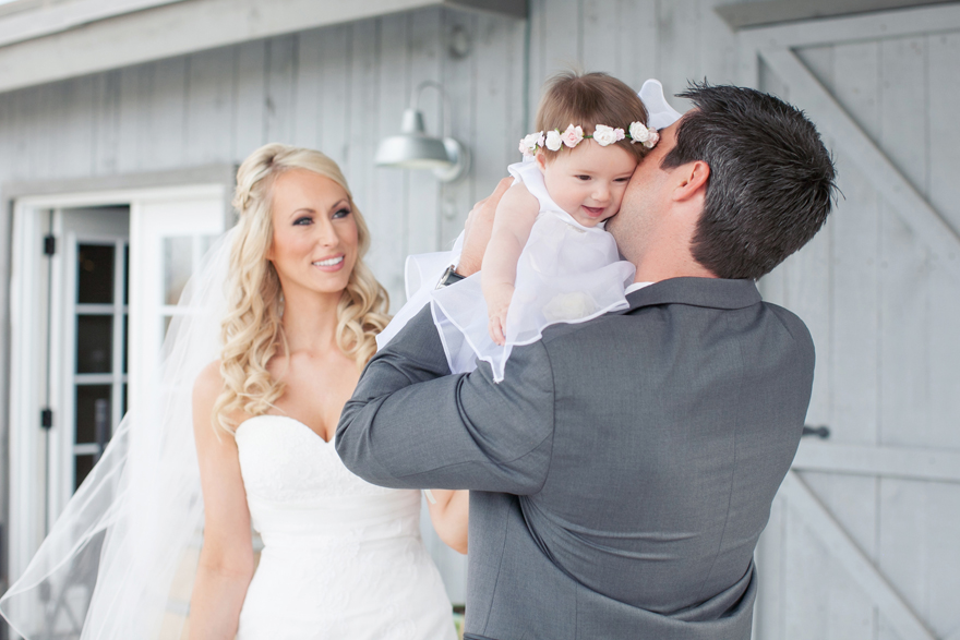 Bride, groom, and their baby daughter on their wedding day. Wedding day photo inspiration and ideas.