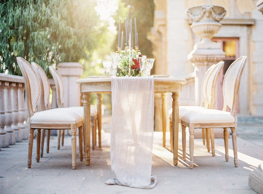 Romantic table with tall candles and a trailing linen runner